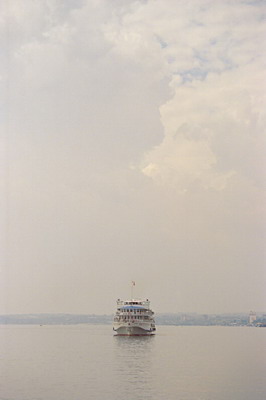 Река Волга, пассажирский круизный теплоход в рейсе, на фоне неба с облаками. Фотография для постеров, календарей, иллюстраций, для оформления интерьеров и выставочных стендов
